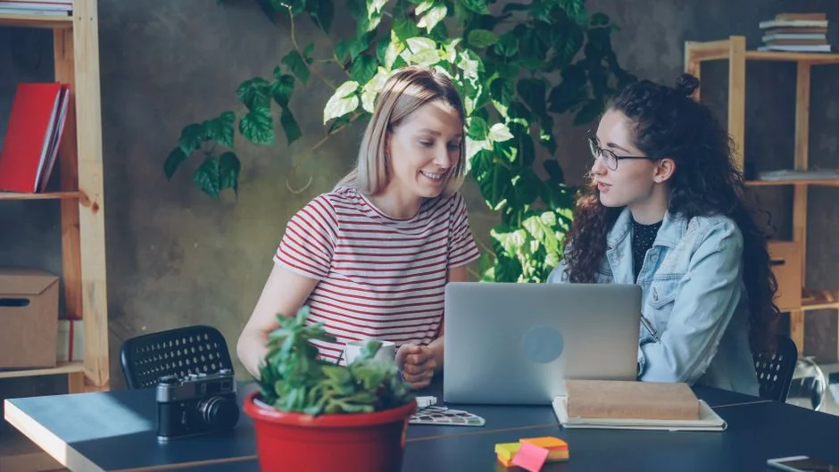 Deux collègues élaborent ensemble une stratégie marketing sur un tableau blanc, en se concentrant sur le contenu généré par les utilisateurs.